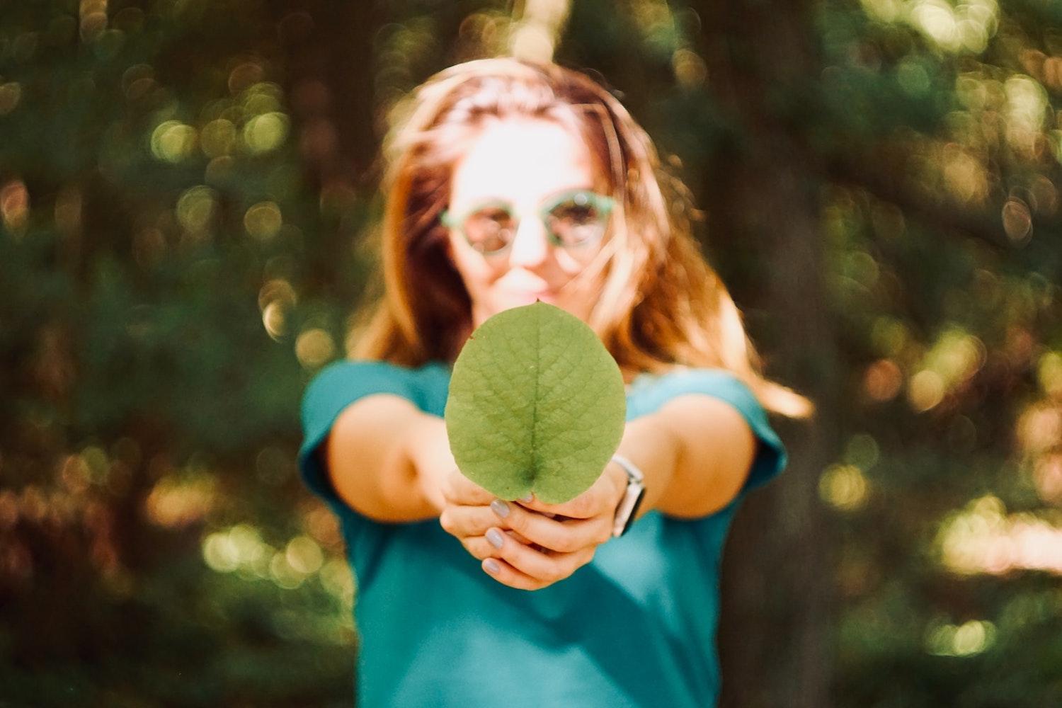 woman holding leaf - ESG and sustainability trends