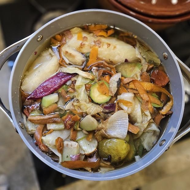 roasted vegetables in a pot with water - how to make vegetable broth from vegetable scraps