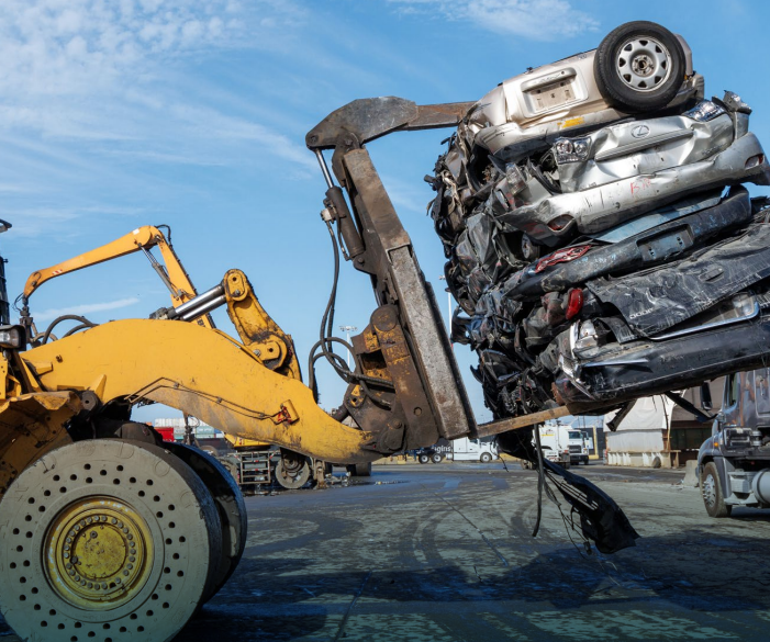 A photo of a forklift holding up 4 crushed cars