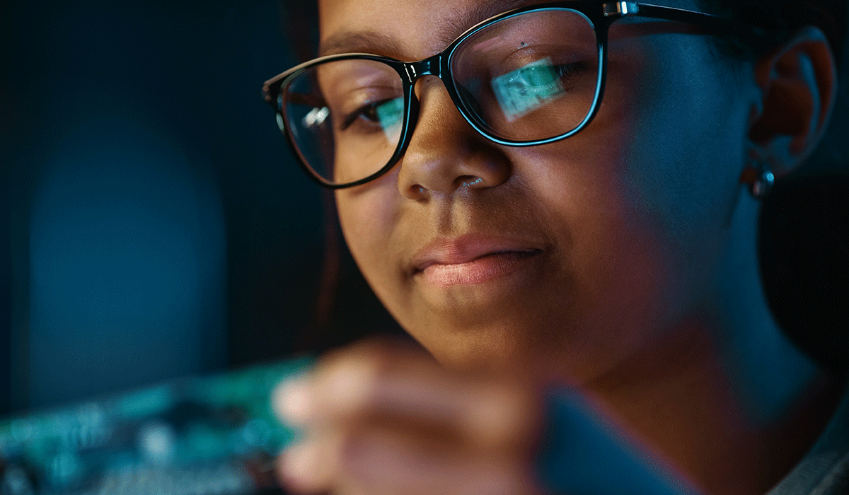 person with computer screen reflected in their glasses