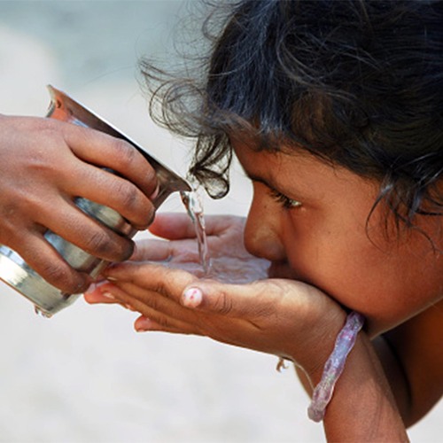 a person drinking water from their cupped hands