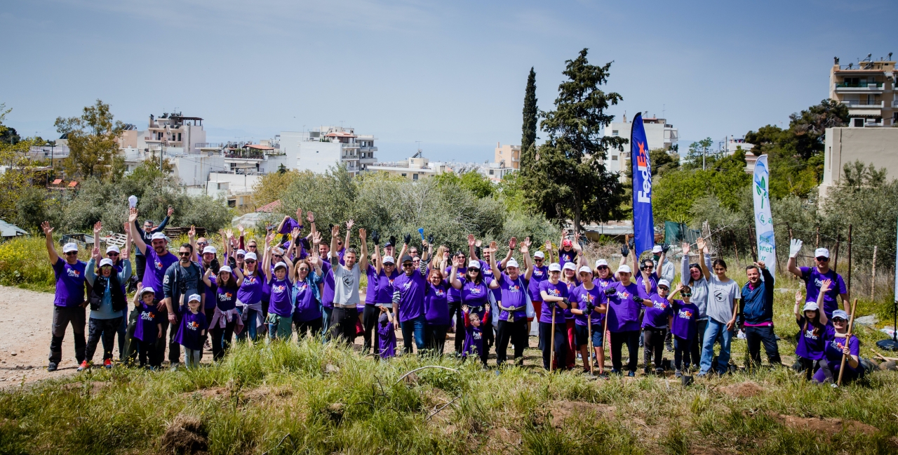 A large group of FedEx employees in Greece standing together at tree planting event
