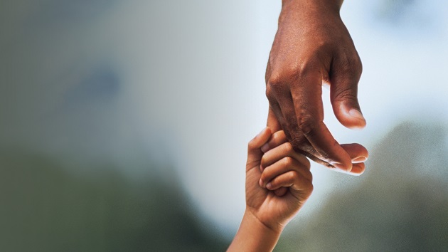 adult hand holding child's hand