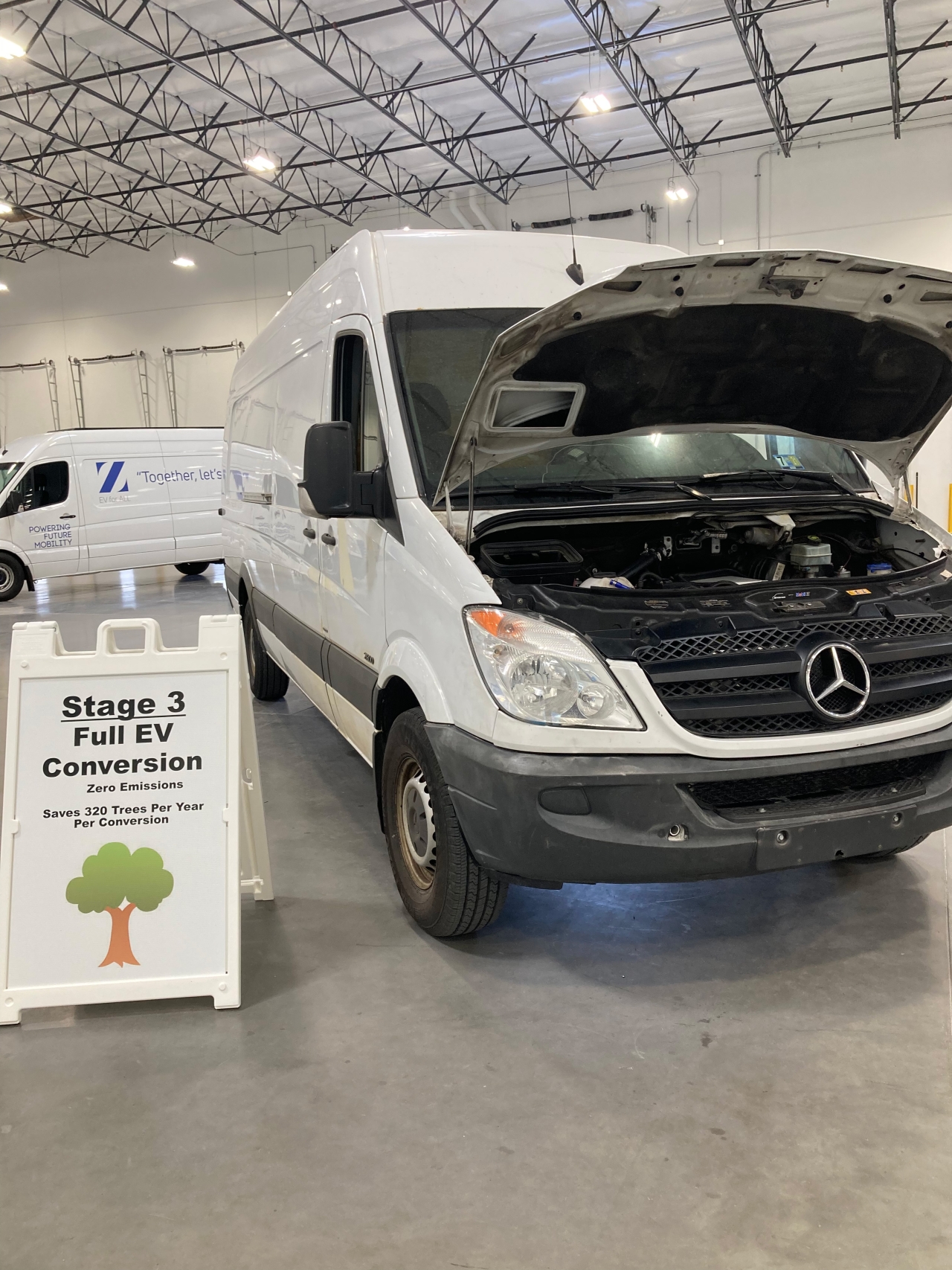 EV in showroom with hood open