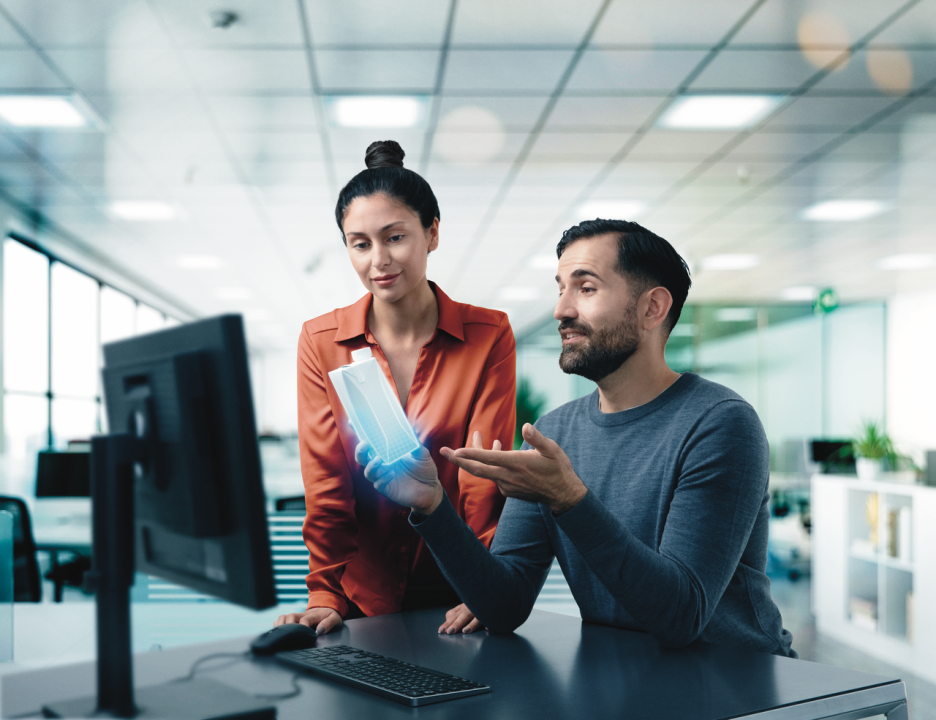 Man and woman holding carton in front of computer