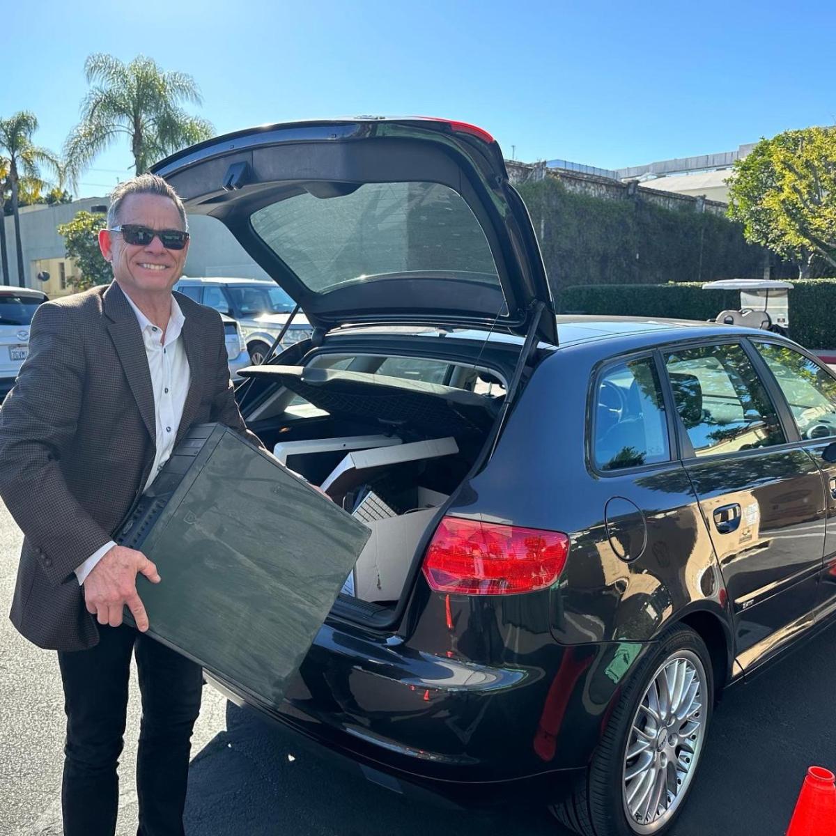 Man holding computer in parking lot