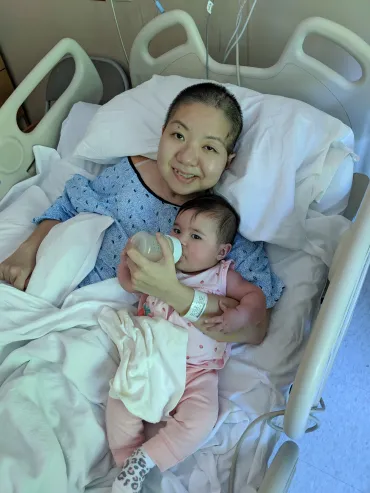 Julia Sine holds daughter, Reina, while in hospital after a stroke.
