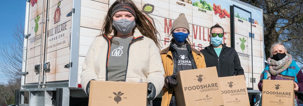 4 masked volunteers carrying boxes