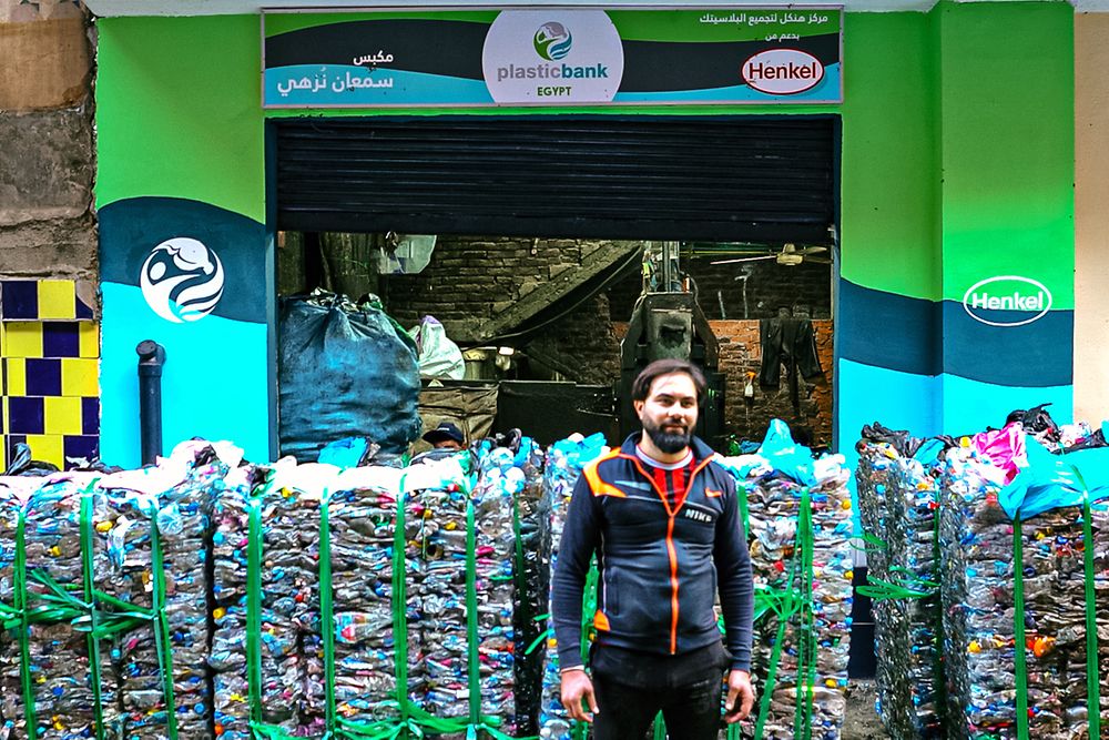 Person standing among piles of plastic to be recycled