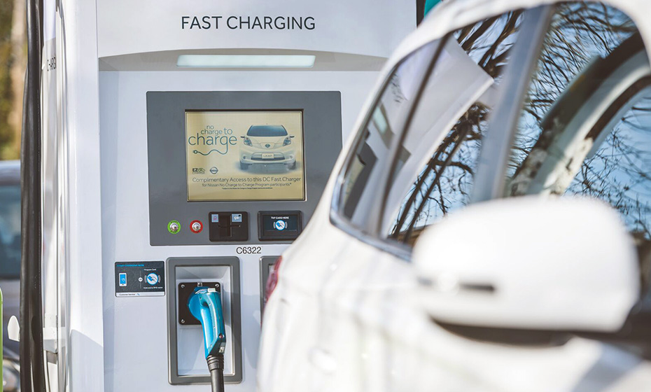 white car in front of a white Fast Charging kiosk