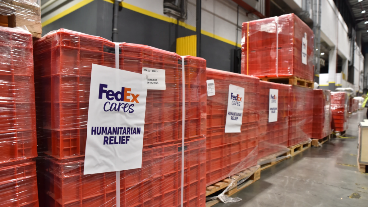 Humanitarian Relief in red crates with a sign that reads "FedEx Cares" 