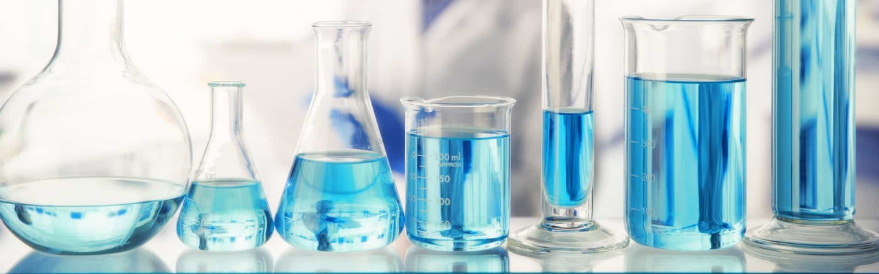 blue liquid in glass measuring bottles