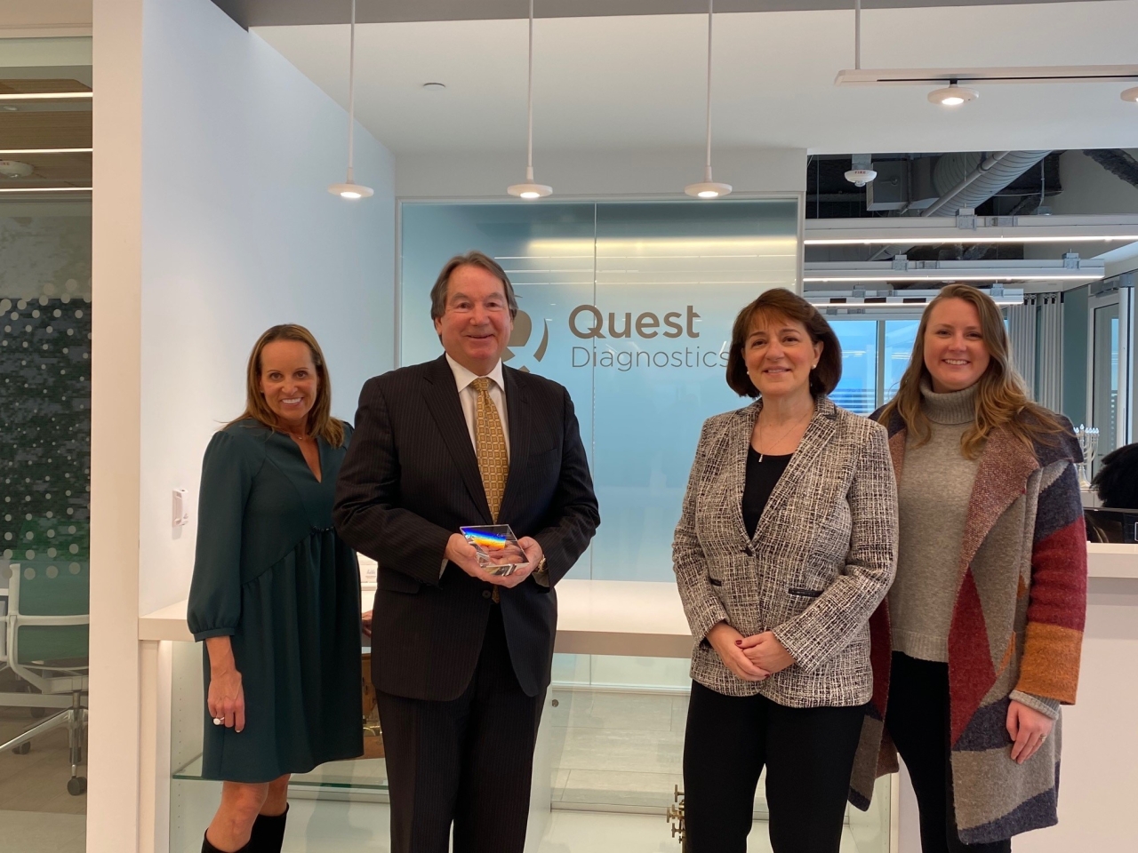 4 people standing in front of Quest Diagnostics logo