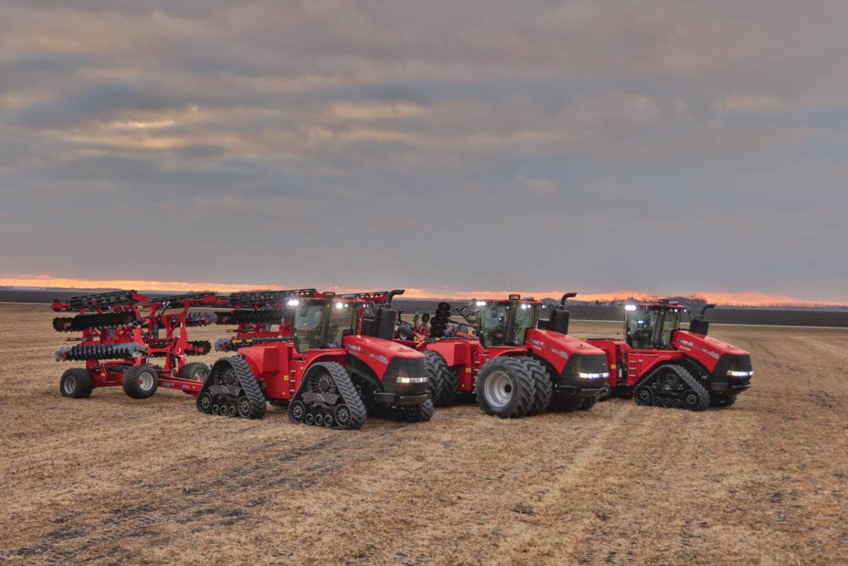 three tractors in an open field