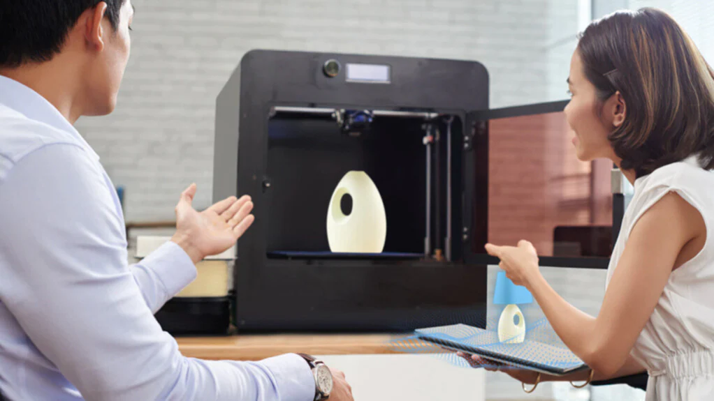2 people using a 3D printer
