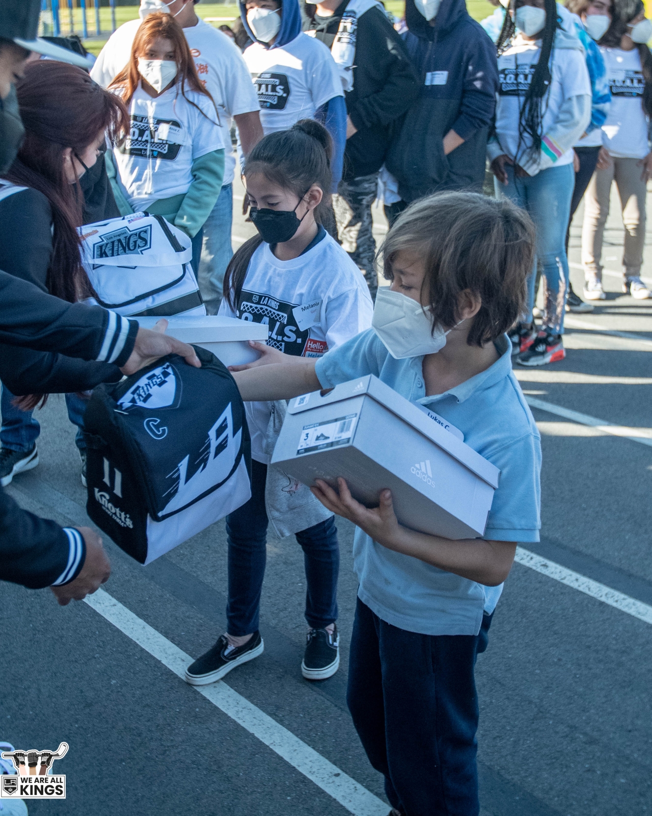 LA Kings staff and volunteers pass out shoes and lunch boxes to students at Longfellow Elementary School in Los Angeles. 