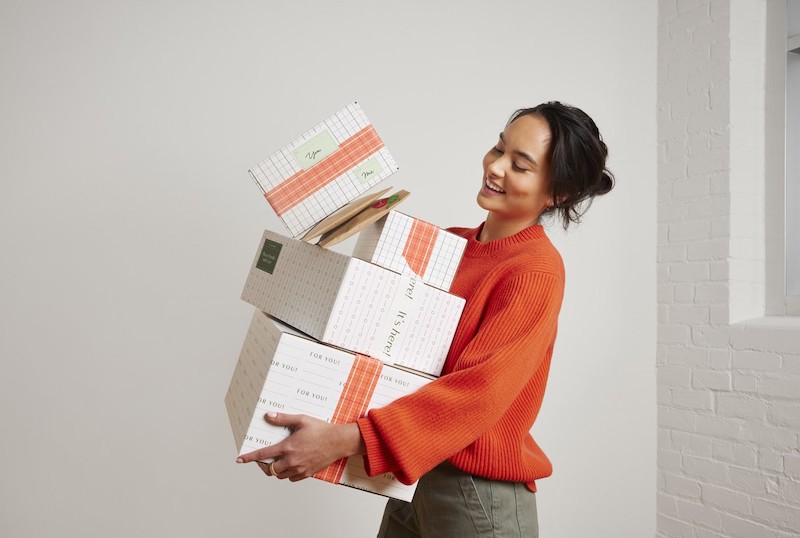 Woman shown carrying packages.