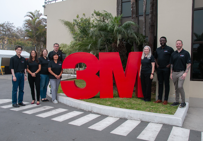 3M Volunteers standing in front of the 3M sign