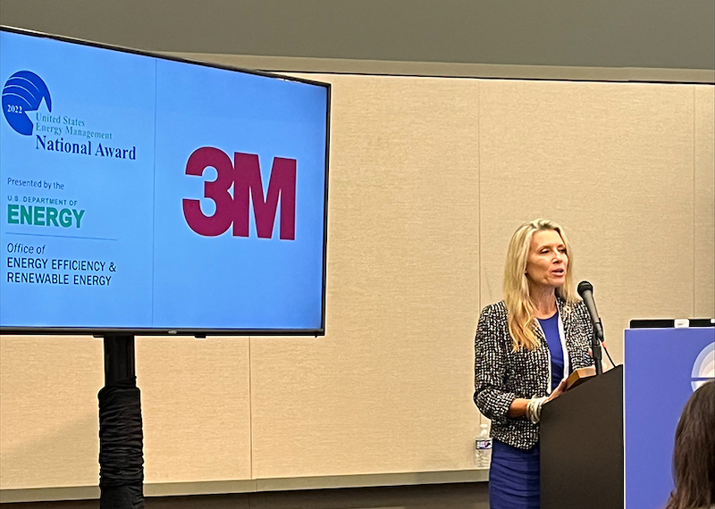 person speaking with 3M's award announcement on a slide