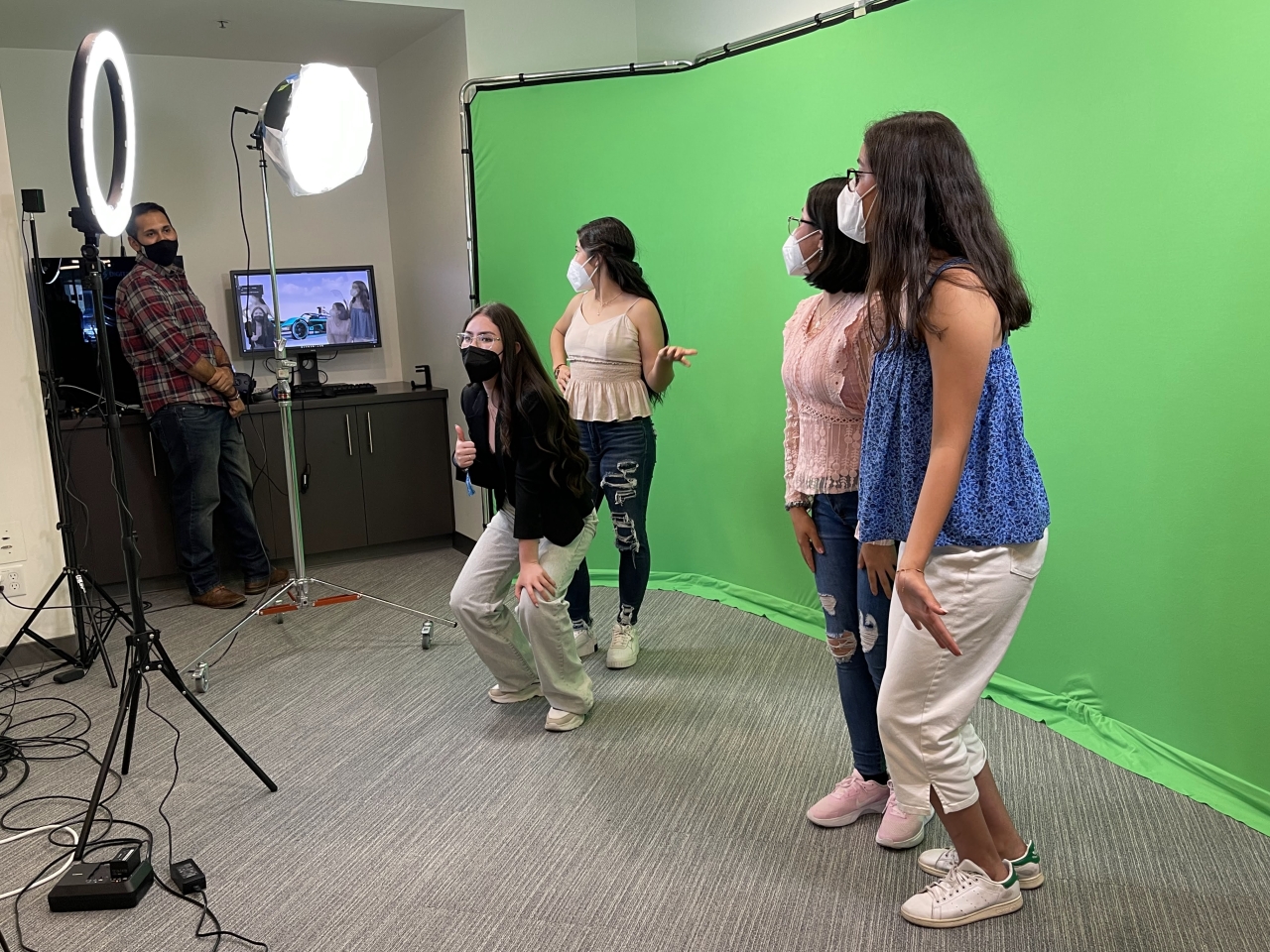 students standing in front of a green screen