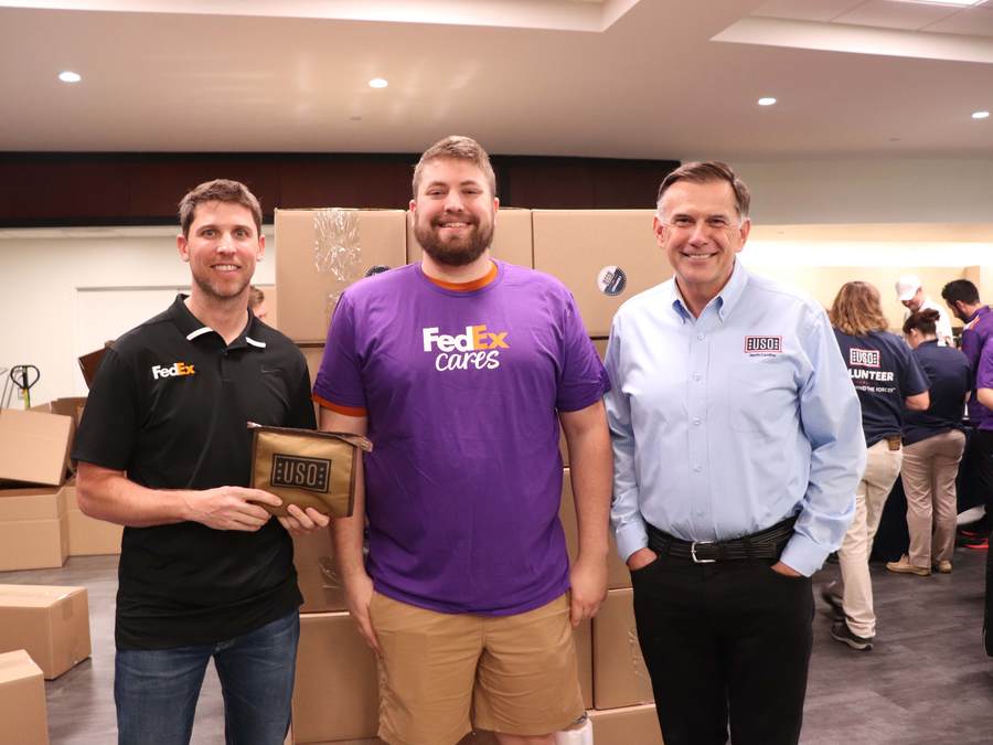 From left to right: Denny Hamlin, NASCAR driver of the #11 FedEx Toyota Camry TRD, Jonathan C. McKinney, FedEx Ground Area Engagement Manager, and Jim Whaley, President USO Southeast Region, pose for a photo during a USO Care Package stuffing event