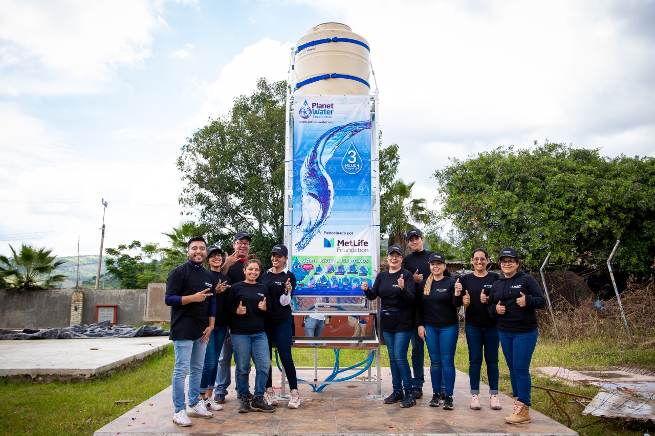 team posing in front of the AquaTower project in La Ladera, Jalisco