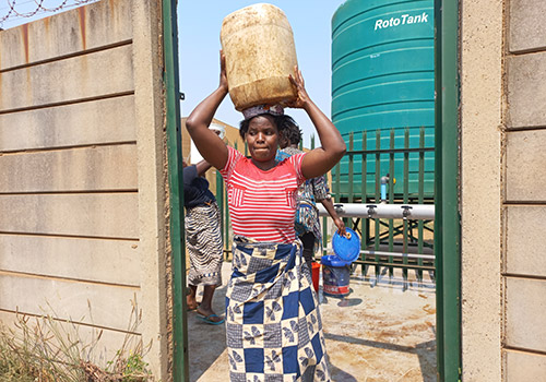 villager carrying water atop her head