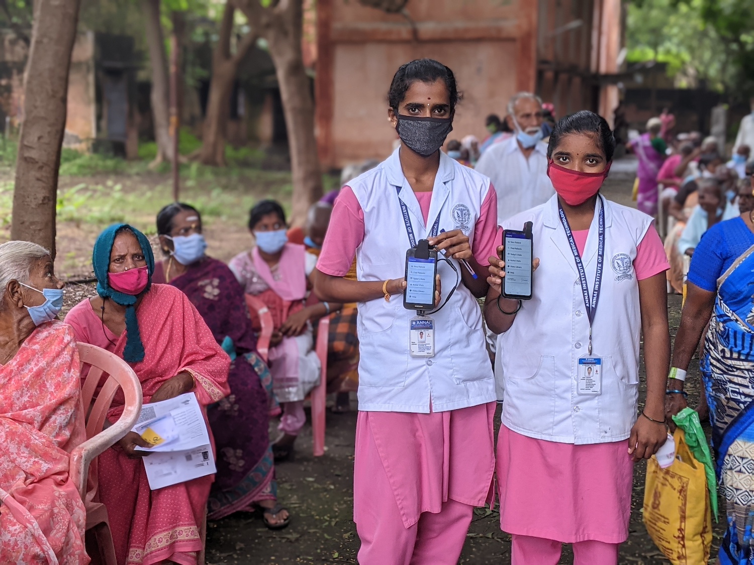 Healthcare workers in India hold their smartphones up to the camera while using Visilant's AI-enabled mobile field app.