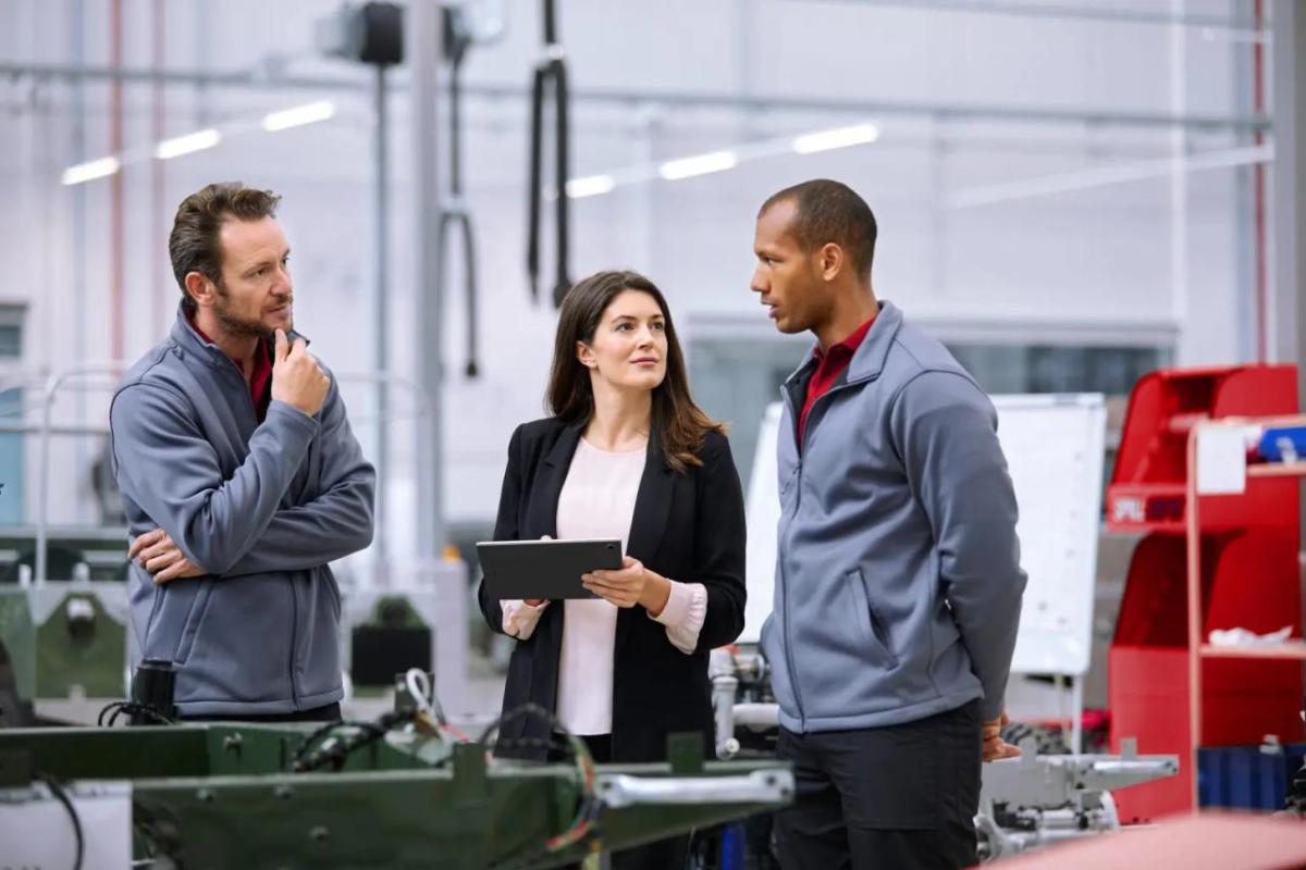 Marine and two others in a manufacturing setting.