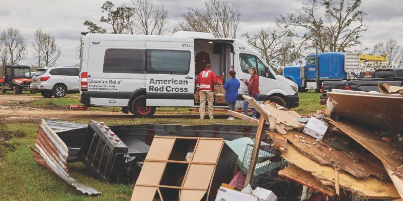 an american red cross van , a pile of debris in front