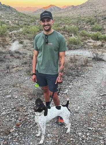 Adam Sandoval with his dog on a hike.