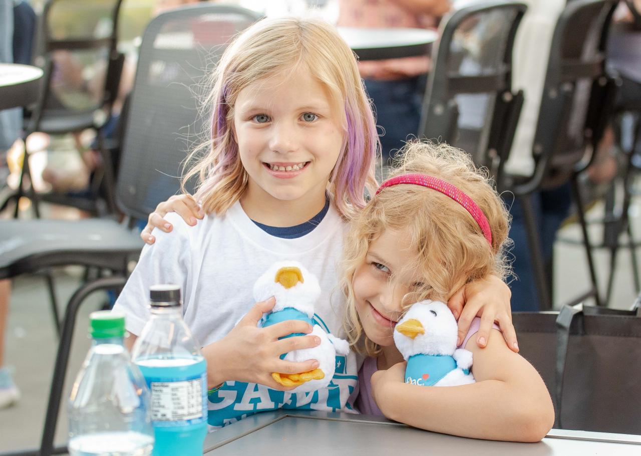 Two children at the Night of Baseball holding Aflac Ducks.