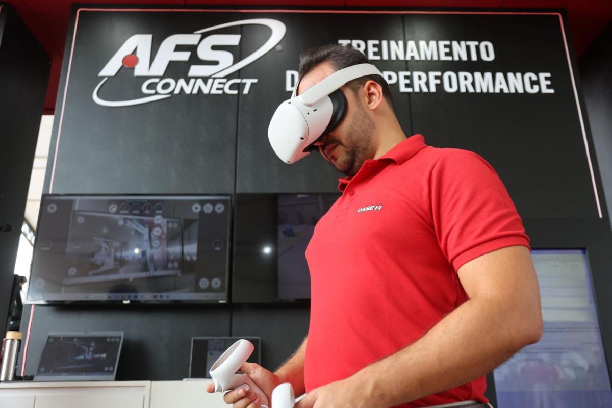 A person in VR headset, using controllers. "AFS connect" sign behind them.