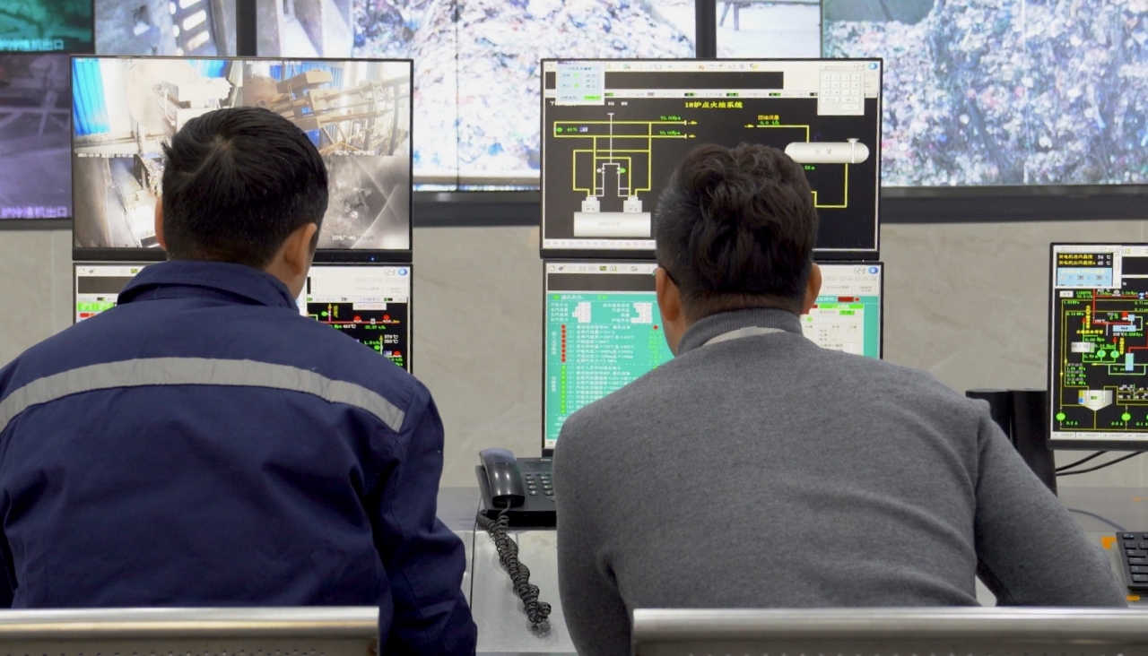 An Alibaba Cloud engineer works with an operator at a waste management plant.
