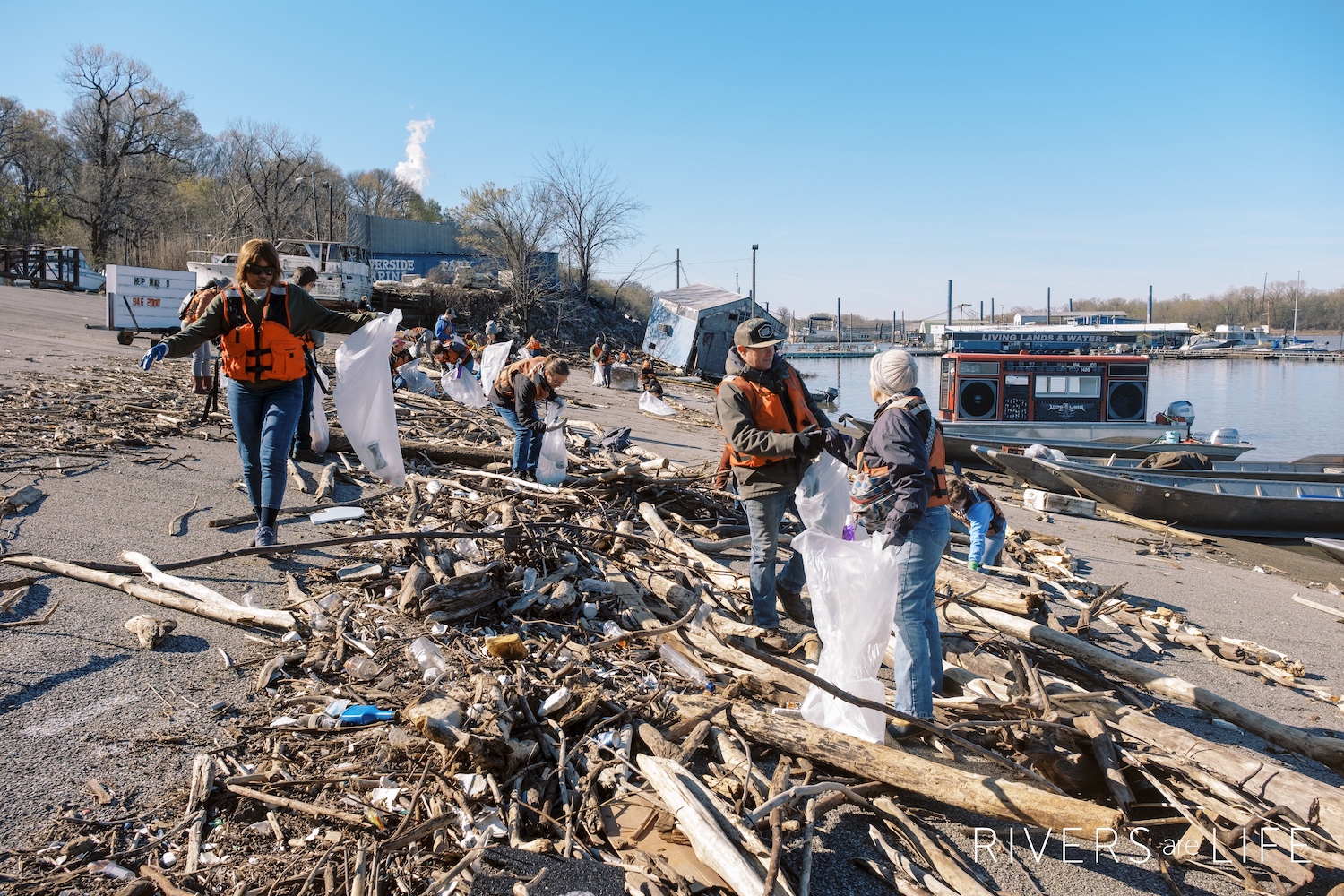 Volunteers clean up trash alongside the Mississippi River. 