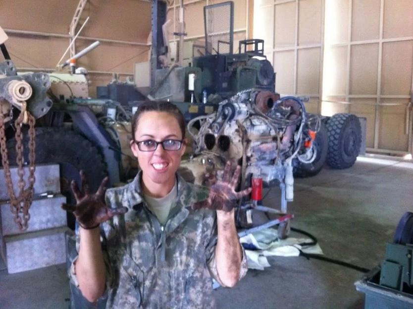 Amber repairing a diesel engine while in military service.