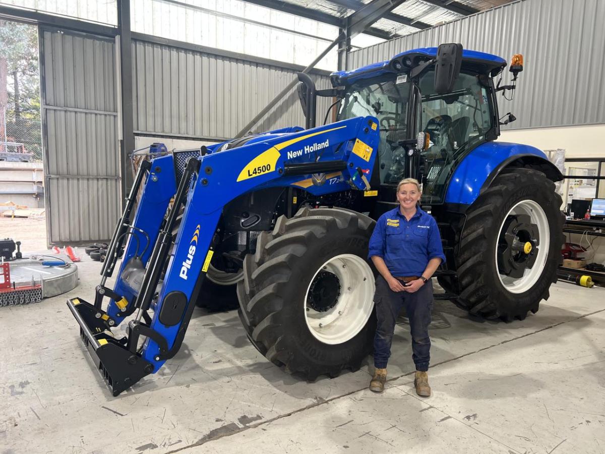 Amy Reid standing by a large tractor.