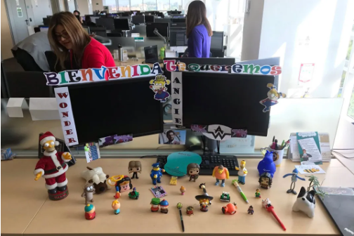 El escritorio de Angie con muchas figuritas y un cartel de bienvenida.