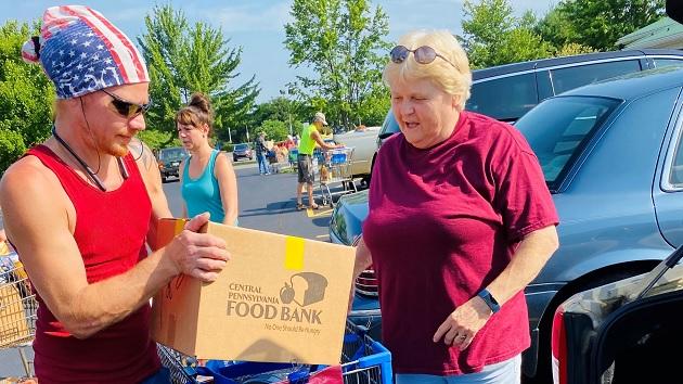 Two people, one holding a box that reads "Central Pennsylvania Food Bank"