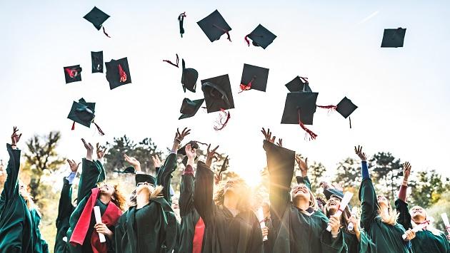 Group of graduates throwing their hat in the air