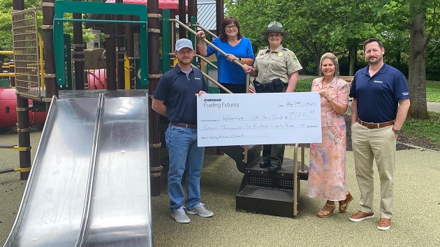 Group holding an oversized check at the new playground