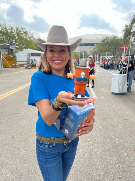 Angela Cole holding a bobble head out of the box.