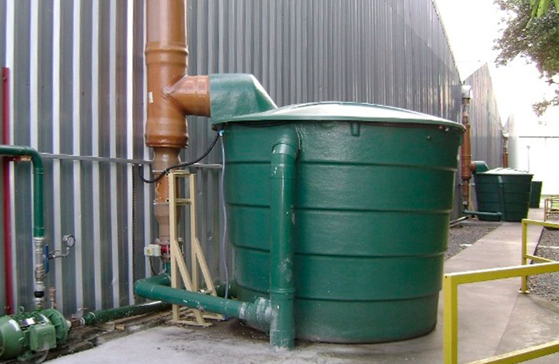 large green enclosed tank outside a building