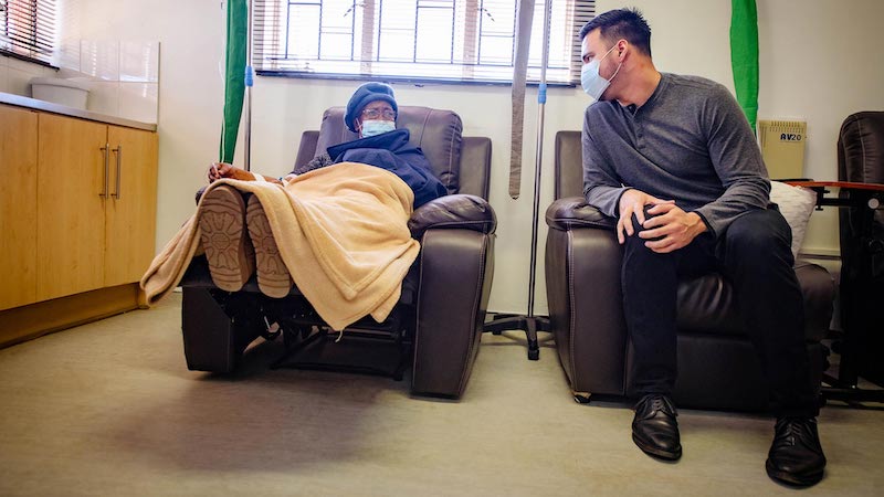 Alejandro Nava from the Rutgers Institute speaks with cancer patient at Senkata Oncology clinic.