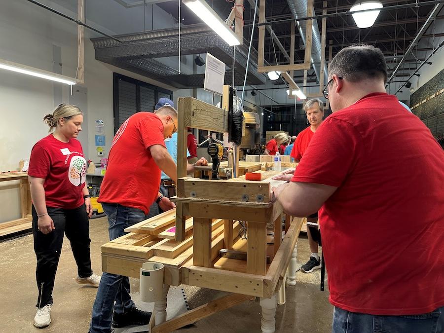 KeyBank volunteers cut and glue sections of bed frames.