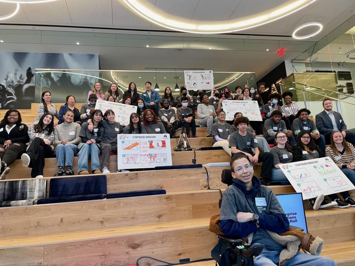 Bleachers with many students seated, holding signs.