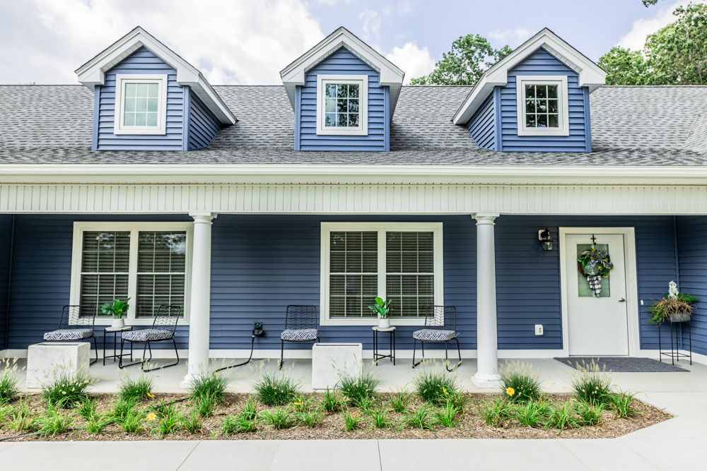 The exterior of a blue house is shown.