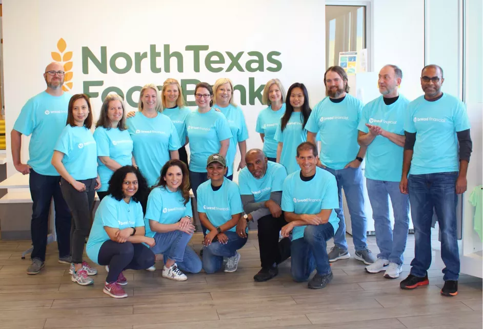 Calvin and a group of others in matching blue "Bread Financial" tshirts, posing in front of a wall with "North Texas Food Bank" on it.