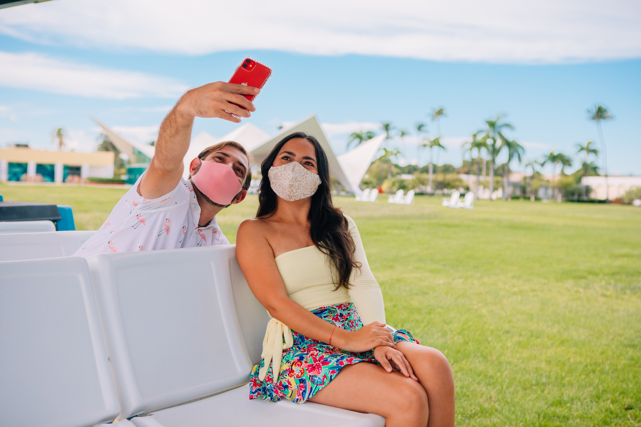 Young man and woman take a selfie while wearing masks