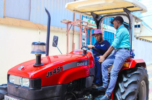 Two people sitting on tractor, talking